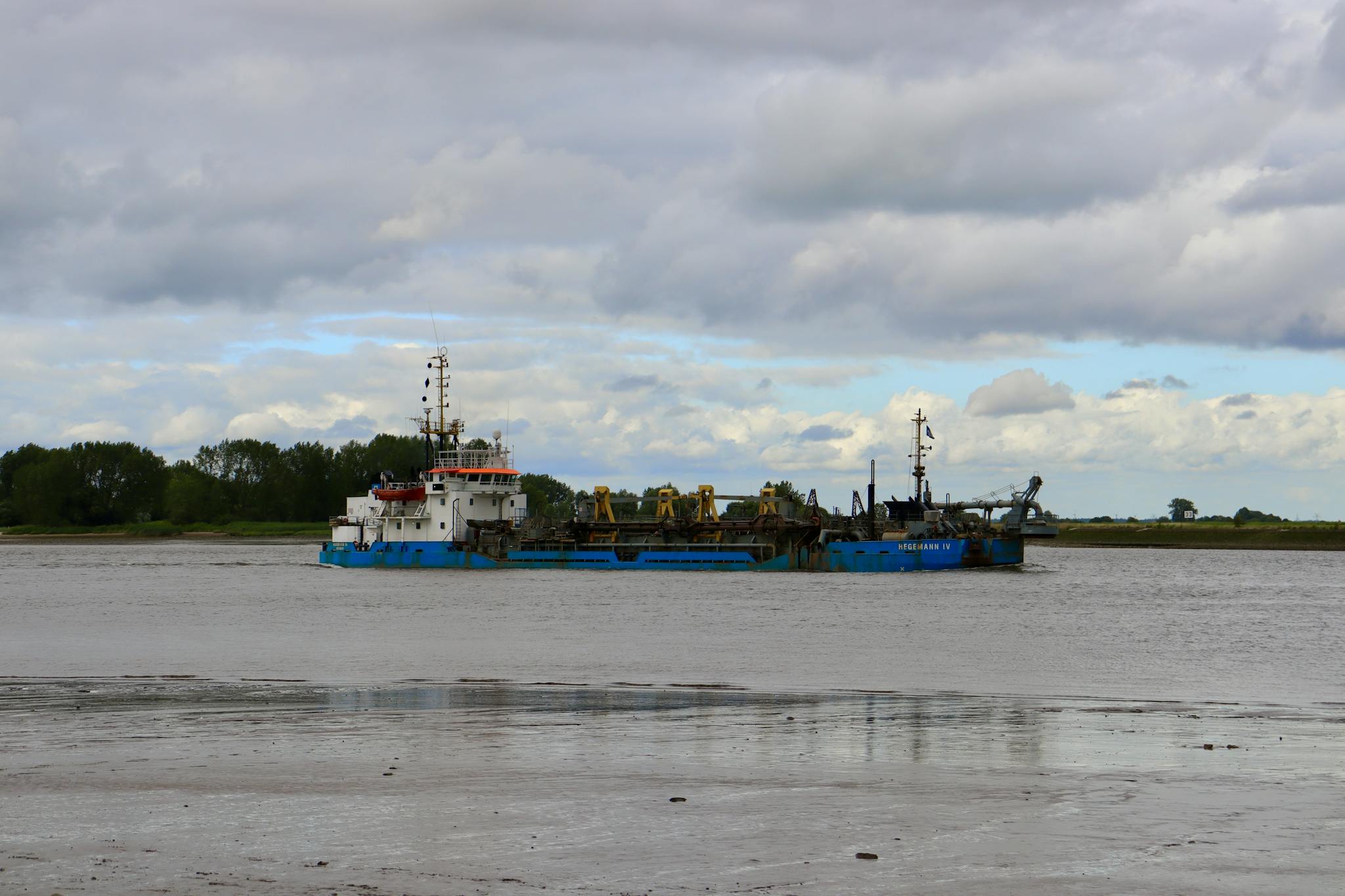 A tugboat navigating a calm sea under a cloudy sky, highlighting maritime industry.